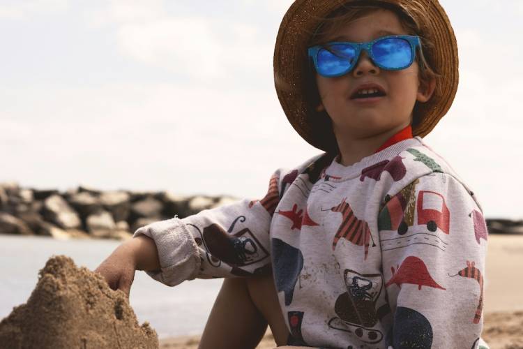 baby building a sandcastle on the beach